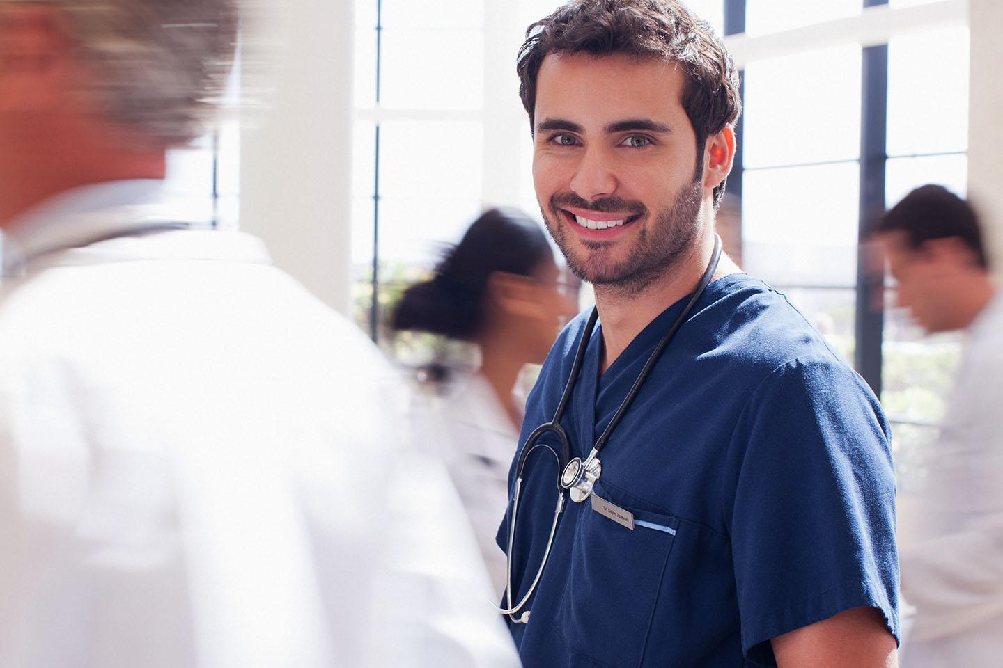 Arzt lächelt, weil er dank verringerten Dokumentationsaufwand mehr Zeit für die Behandlung der Patienten hat